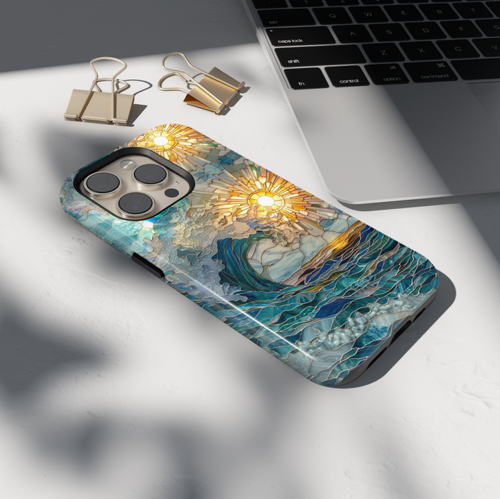 Stained glass ocean wave phone case with golden sunburst and layered blue sea design on a tough protective case