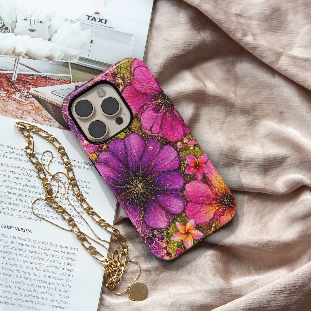 Purple and pink floral iPhone 17 Pro Max case with bold artistic flower design and gold speckled details.