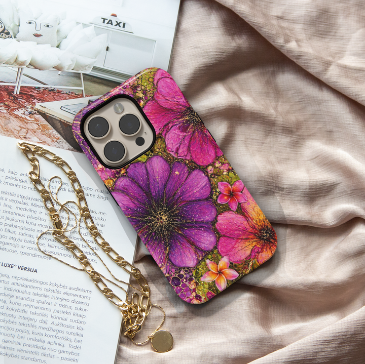 Purple and pink floral iPhone 17 Pro Max case with bold artistic flower design and gold speckled details.