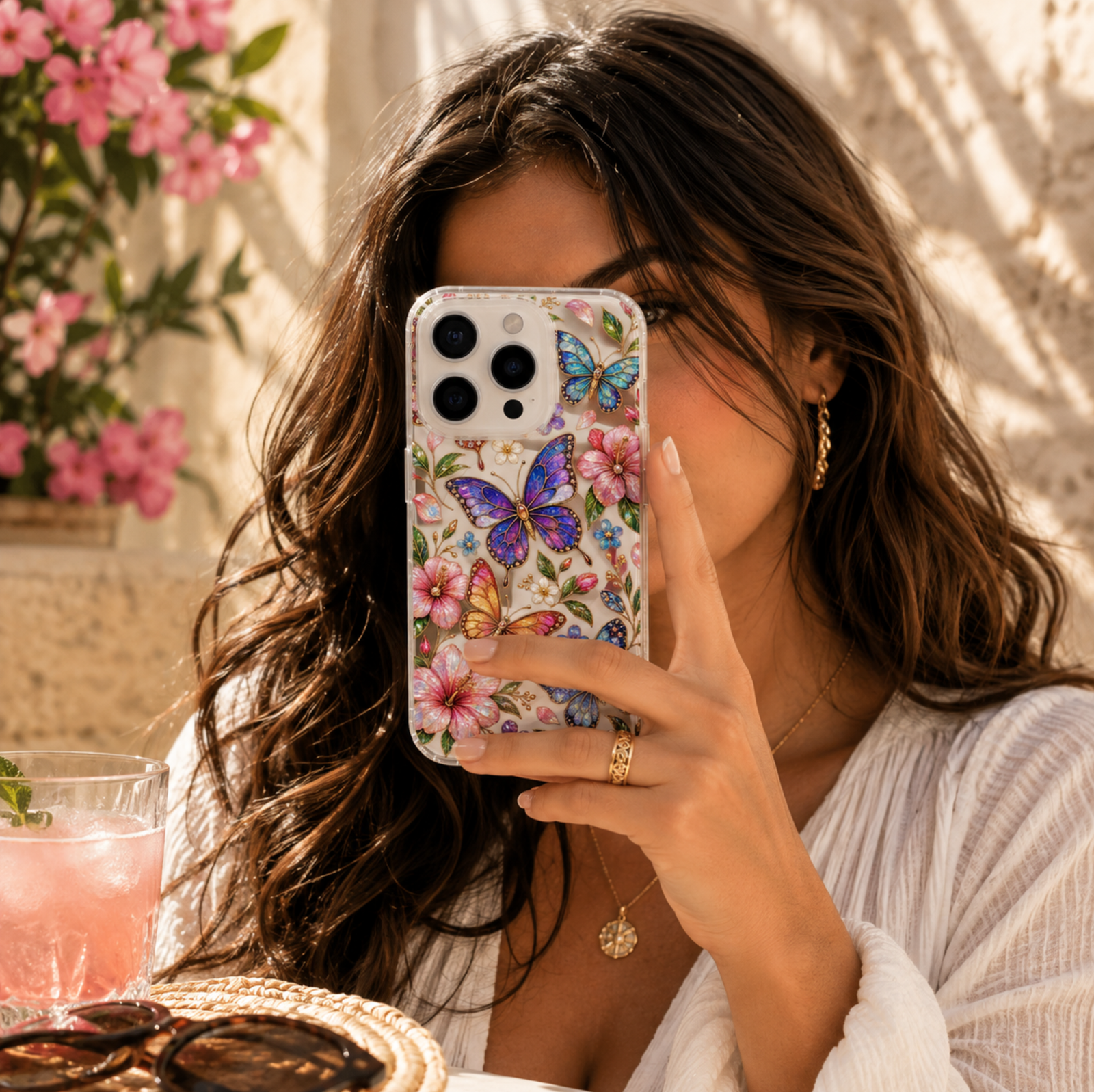Clear MagSafe iPhone case with jeweled blue, purple, pink and orange butterflies, hibiscus flowers, green leaves and colorful floral details.