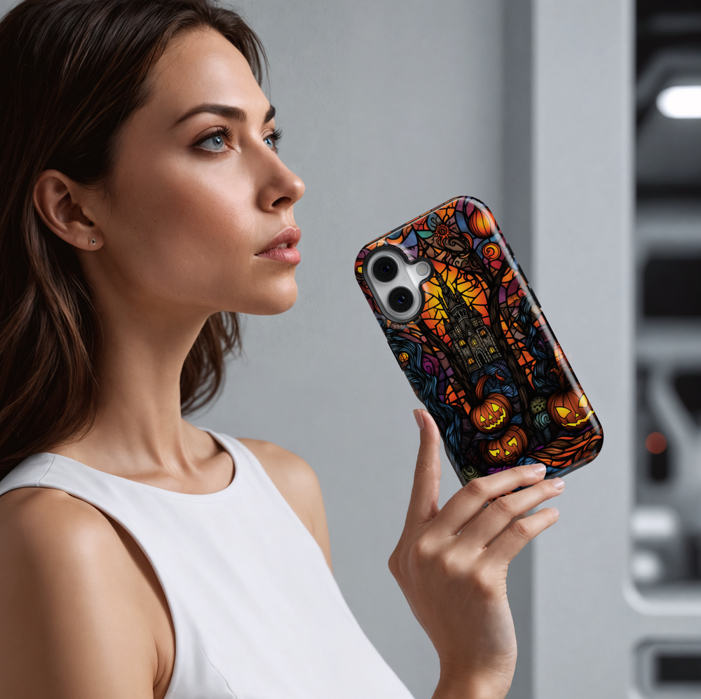Stained glass Halloween iPhone case with glowing jack-o'-lanterns, spooky trees, and a haunted castle in vibrant orange, purple, and black tones.