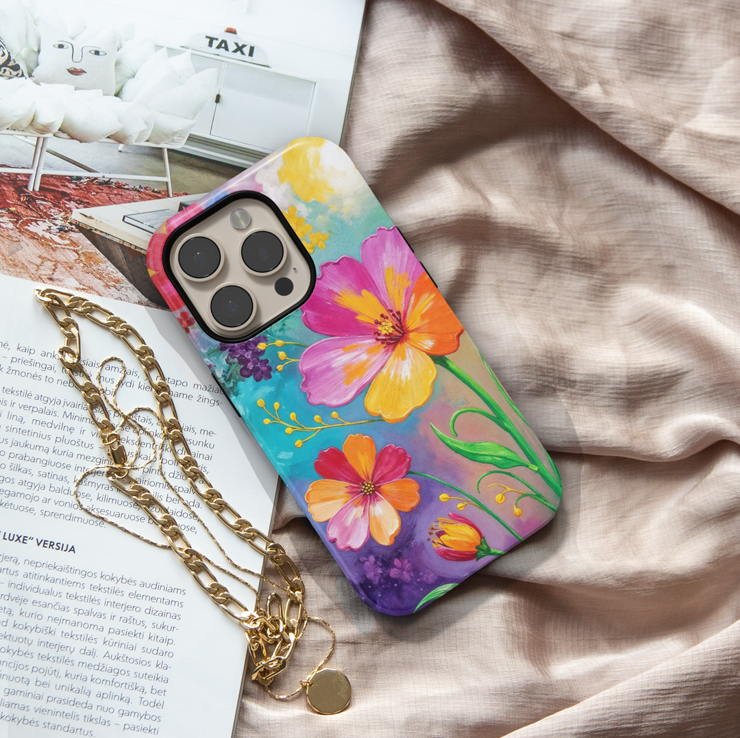 Colorful floral iPhone case featuring vibrant hand-painted flowers in pink, orange, yellow, and purple with a bright botanical garden design.