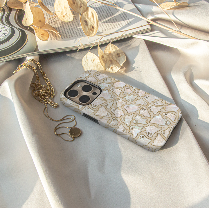 Cute ghost iPhone case featuring tiny ghost illustrations on a pearlescent opal background with elegant gold outlines.