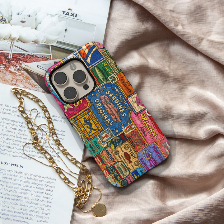 Vintage sardine tin iPhone case featuring colorful retro seafood labels and coastal-inspired collage artwork.
