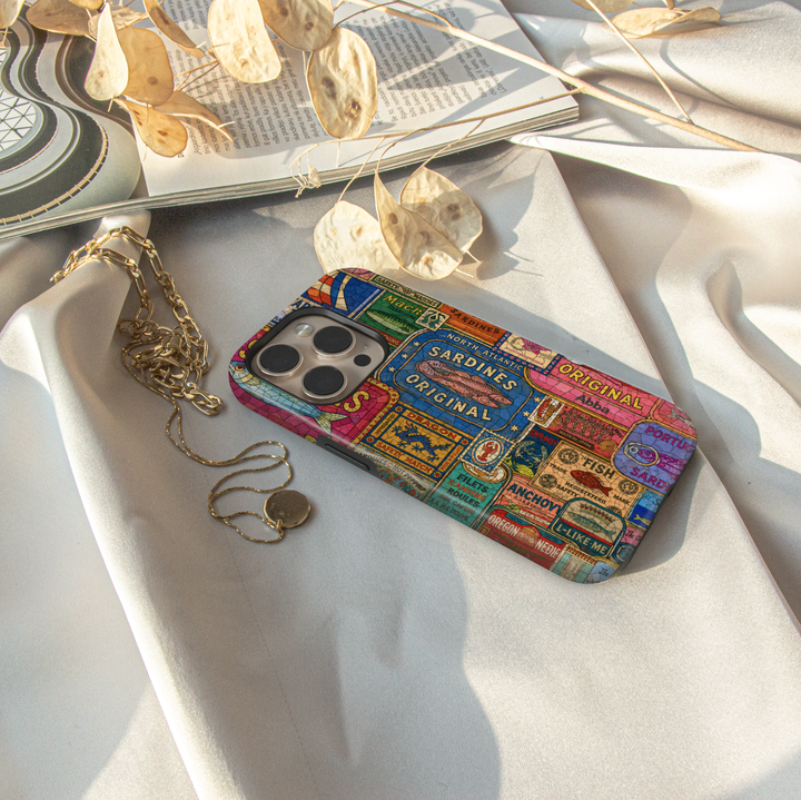 Vintage sardine tin iPhone case featuring colorful retro seafood labels and coastal-inspired collage artwork.