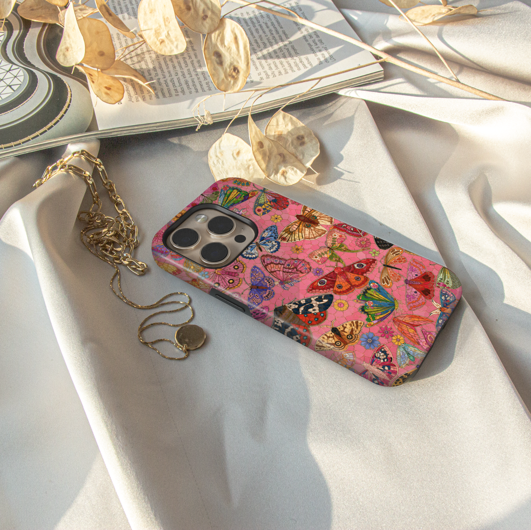 Pink butterfly iPhone case featuring colorful butterflies, moths, flowers, and whimsical nature-inspired artwork.