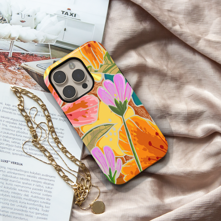 Colorful floral iPhone case featuring oversized wildflowers, botanical leaves, and vibrant retro-inspired floral artwork.