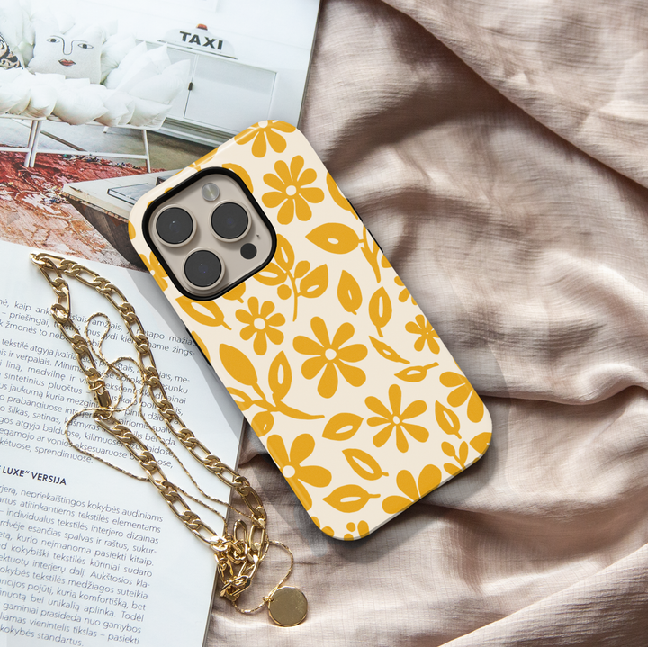 Minimalist yellow floral iPhone case featuring retro daisy flowers and botanical leaves on a soft ivory background.
