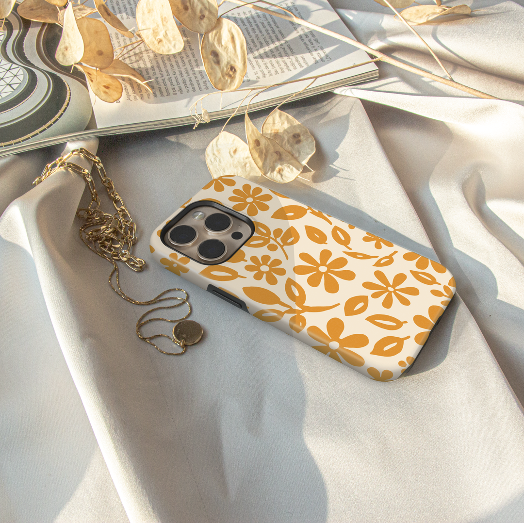 Minimalist yellow floral iPhone case featuring retro daisy flowers and botanical leaves on a soft ivory background.