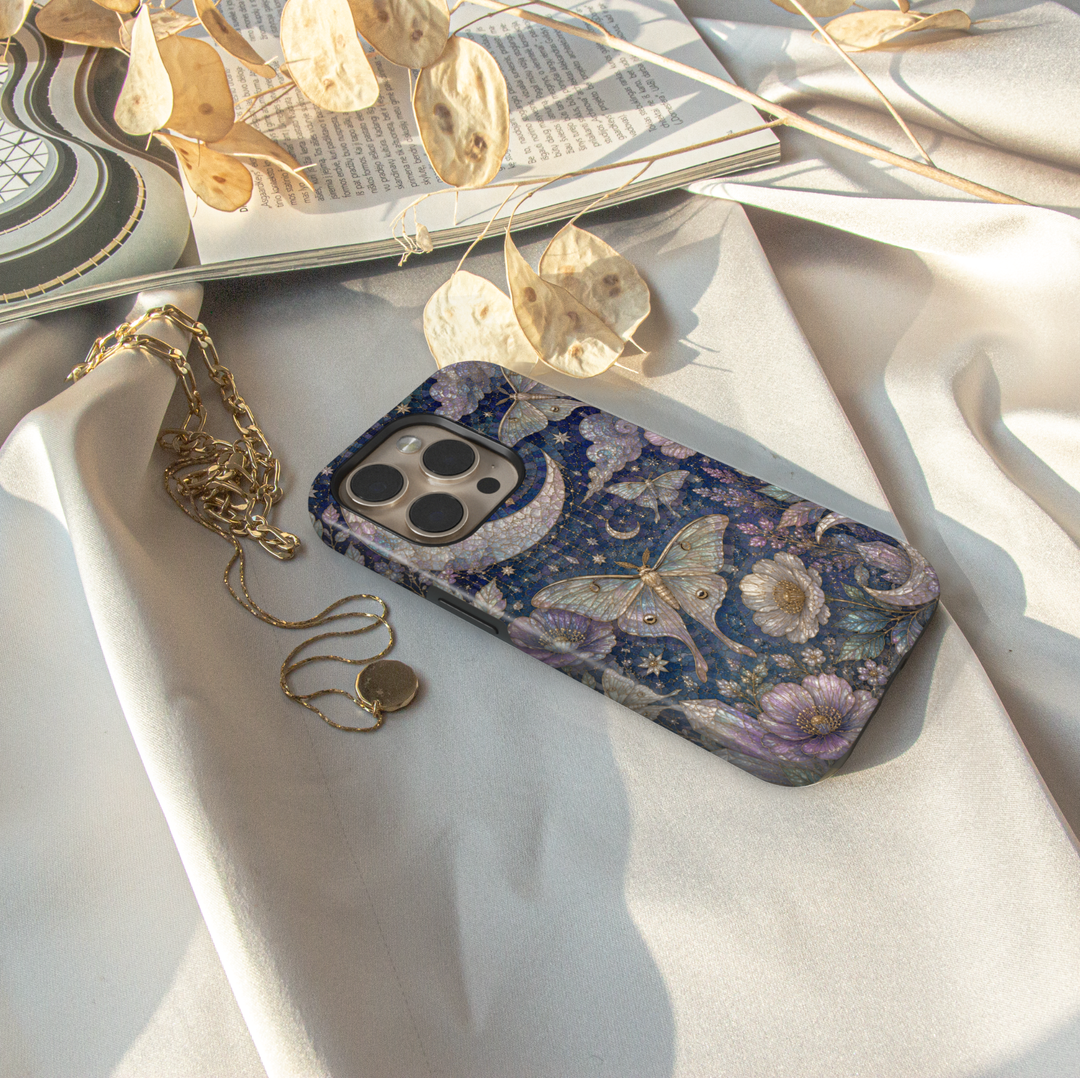 Celestial iPhone case featuring luna moths, crescent moon, stars, lavender flowers, clouds, and elegant midnight floral artwork.