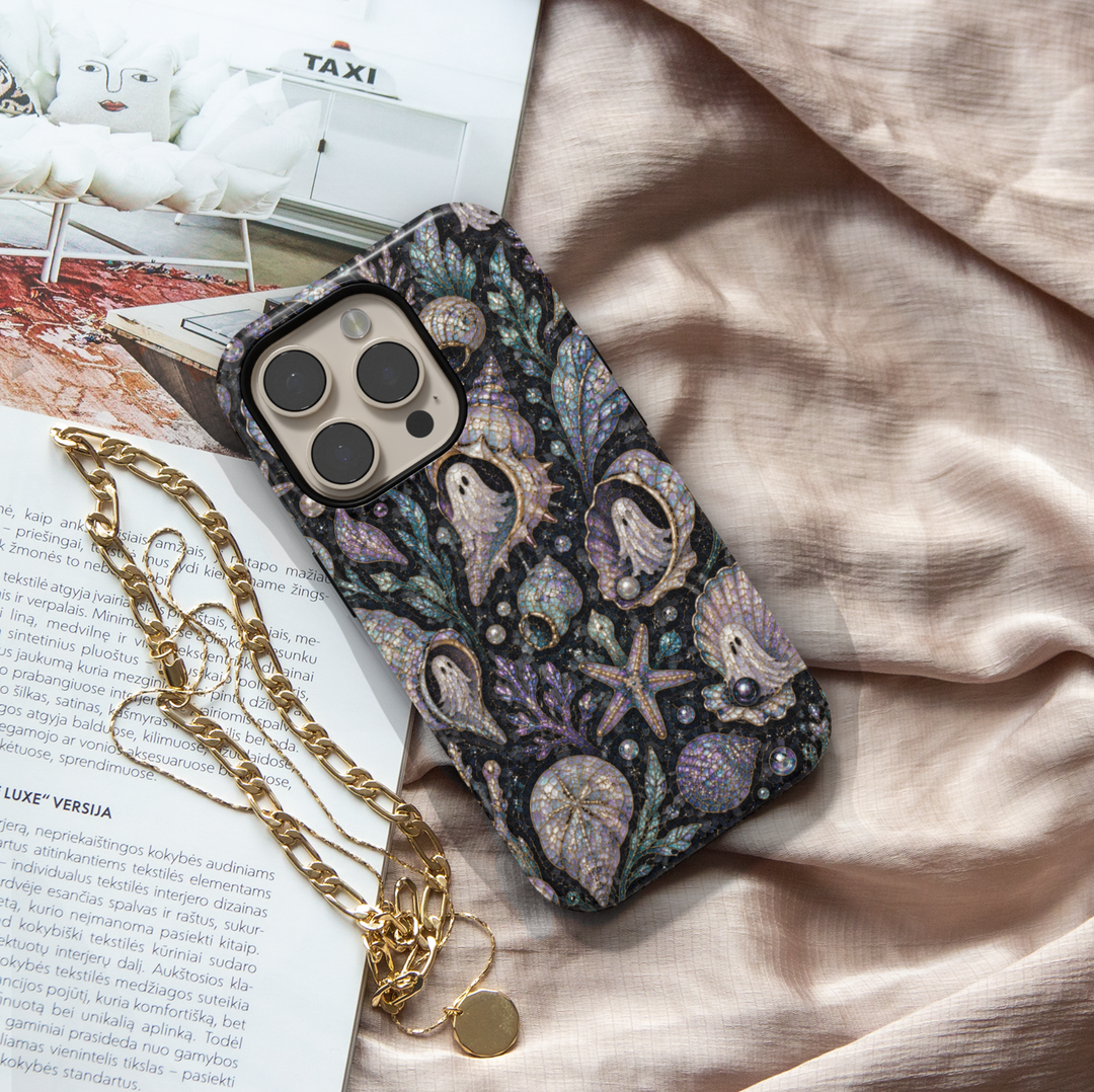 Midnight coastal Halloween iPhone case featuring pearl ghosts inside seashells with starfish, coral, sea glass, pearls, and iridescent ocean details.