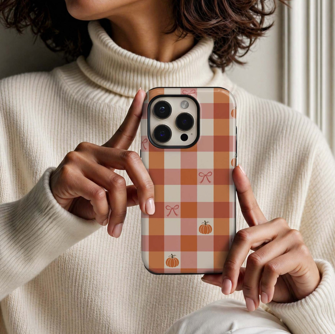 Pumpkin Picnic Tough iPhone Case featuring pink, pumpkin orange, terracotta and cream gingham checks with dainty bows and mini pumpkins in a girly autumn design.