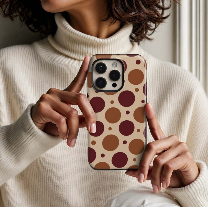 Harvest Bubbles Tough iPhone Case featuring oversized and mini burgundy, caramel and chestnut polka dots on a warm creamy beige background.