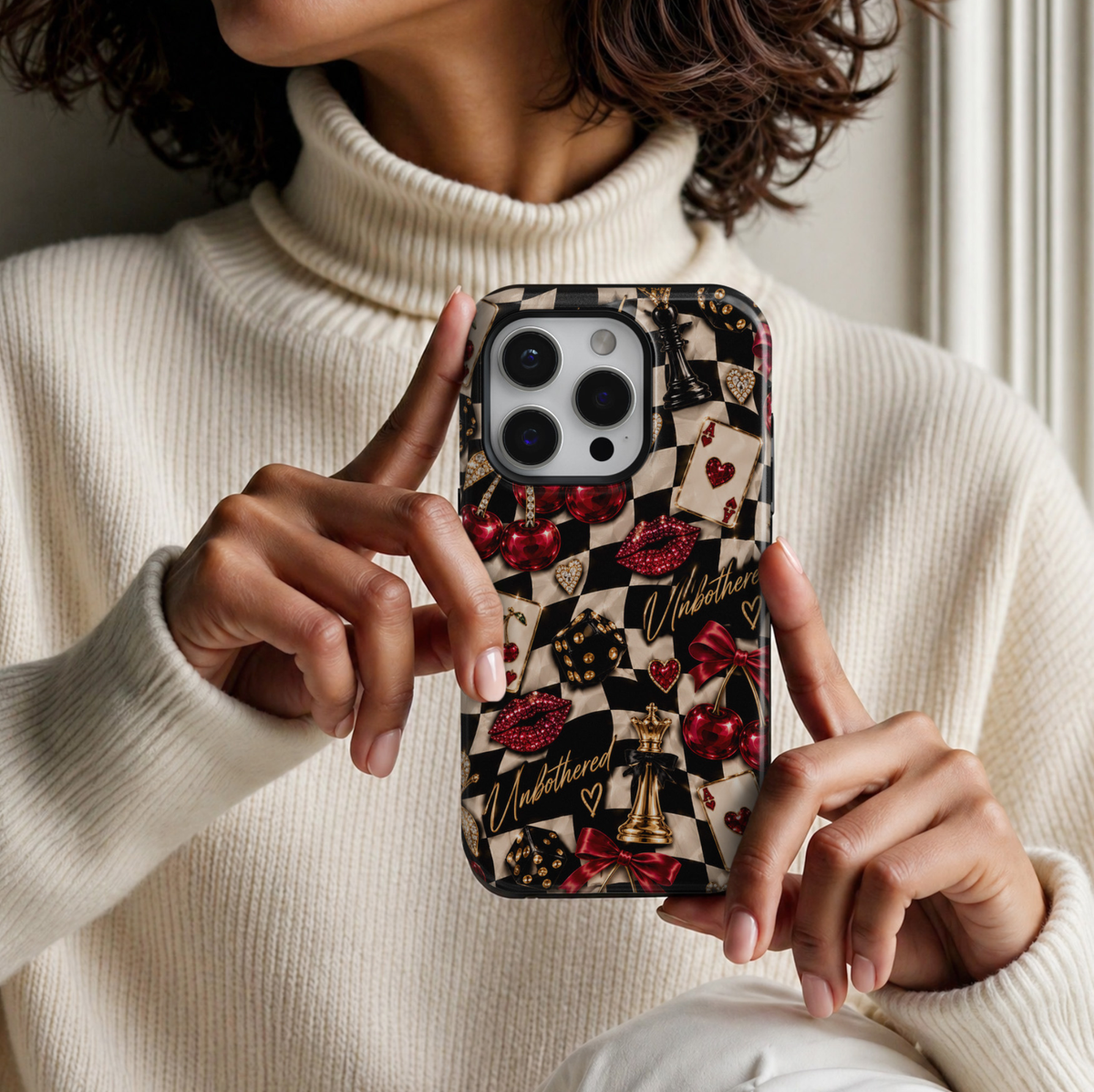 CASELIX Cherry Checkmate iPhone 18 Pro Max tough phone case featuring a black and cream checkerboard pattern with glossy red cherries, jeweled lips, gold chess pieces, playing cards, dice, red satin bows, and gold Unbothered lettering. Trendy preppy checkerboard phone case for women with a bold, glamorous, girls' night out aesthetic and glossy printed finish.
