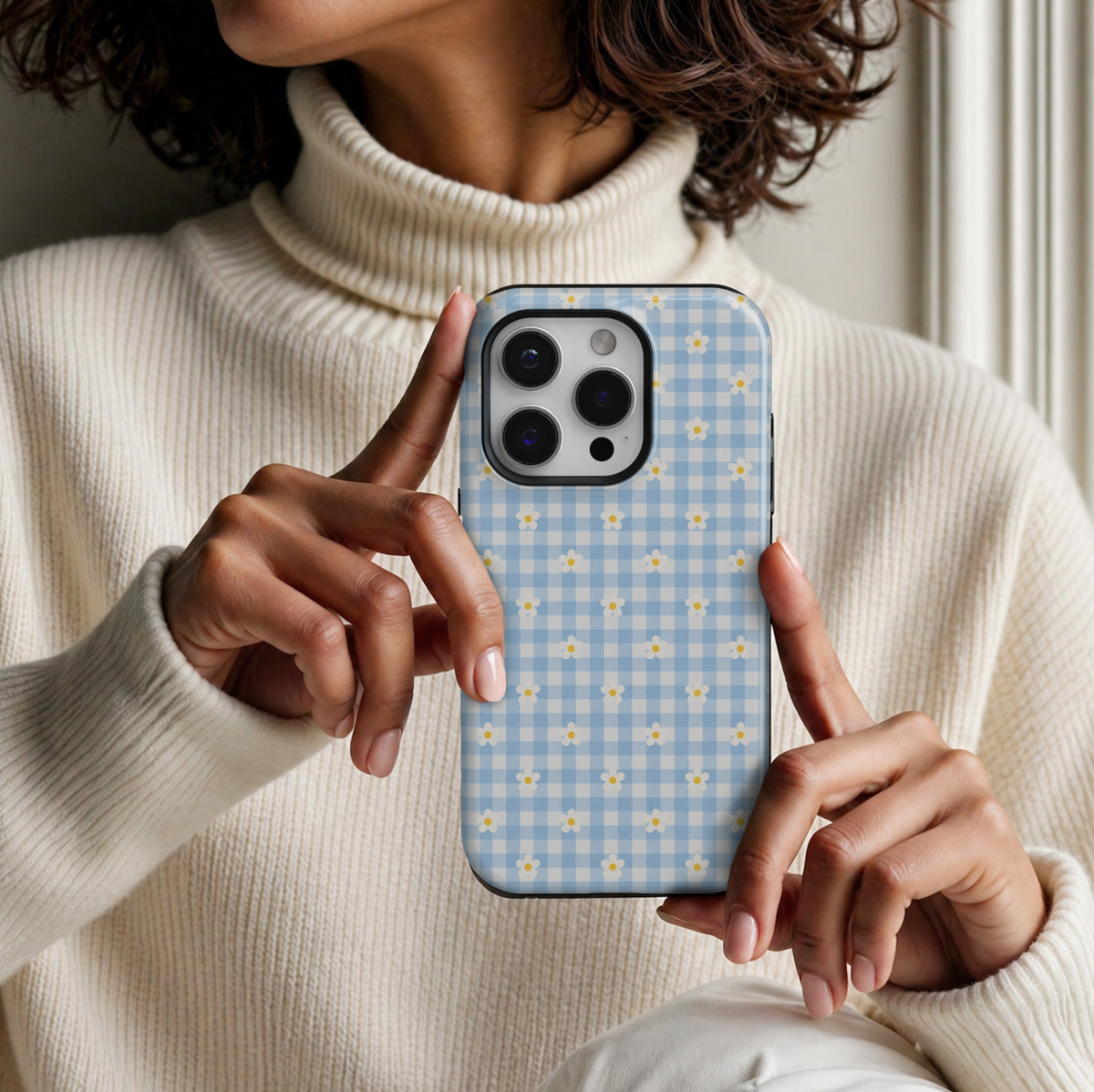 CASELIX Daisy Blue Gingham iPhone 18 Pro Max tough phone case featuring pastel baby blue and white gingham checks with tiny white daisy flowers and yellow centers. Cute floral checkered phone case for women with a glossy printed finish, soft girl aesthetic, and charming cottagecore-inspired design.