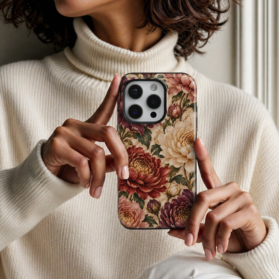 CASELIX November Birth Flower Chrysanthemum Glow iPhone 18 Pro Max tough phone case featuring luxurious burgundy, champagne ivory, dusty rose, and plum chrysanthemum blossoms with delicate gold detailing, deep green botanical leaves, and an elegant pearl-inspired ivory background. A sophisticated autumn floral phone case for women with a romantic vintage aesthetic, perfect for November birthday gifts, fall fashion, and elegant everyday styling.