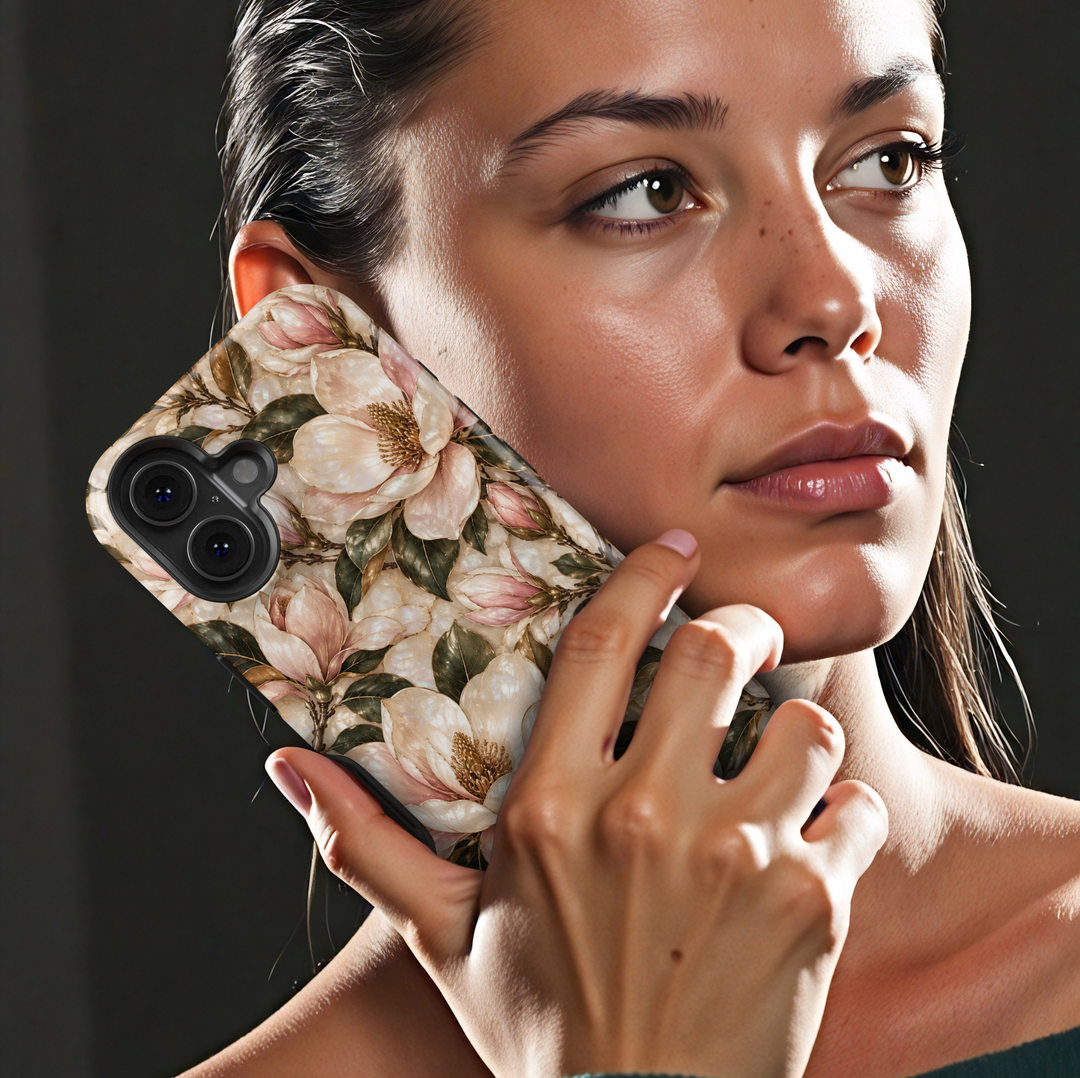 January birth flower iPhone 18 Pro Max case featuring Magnolia Grace with elegant ivory and blush pink magnolia blossoms, golden botanical accents, and deep green leaves on a champagne-inspired background with a glossy printed finish.