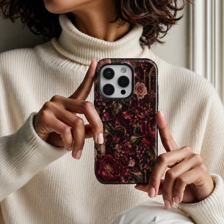 Midnight Garden iPhone 18 Pro Max tough phone case featuring luxurious deep burgundy peonies, dusty pink roses, delicate plum blossoms, dark olive foliage, rich purple grape clusters, and antique gold garden architecture against a dramatic black background with a glossy printed finish.
