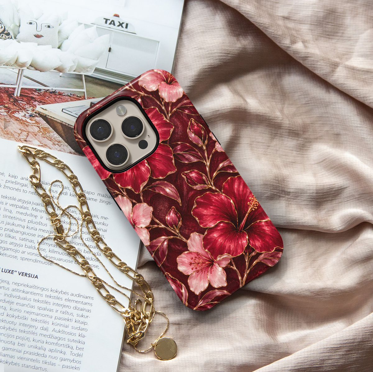 CASELIX Ruby Hibiscus iPhone case featuring vibrant ruby red and blush pink hibiscus flowers with delicate gold outlines, floral buds and a deep burgundy background in a glossy printed finish.