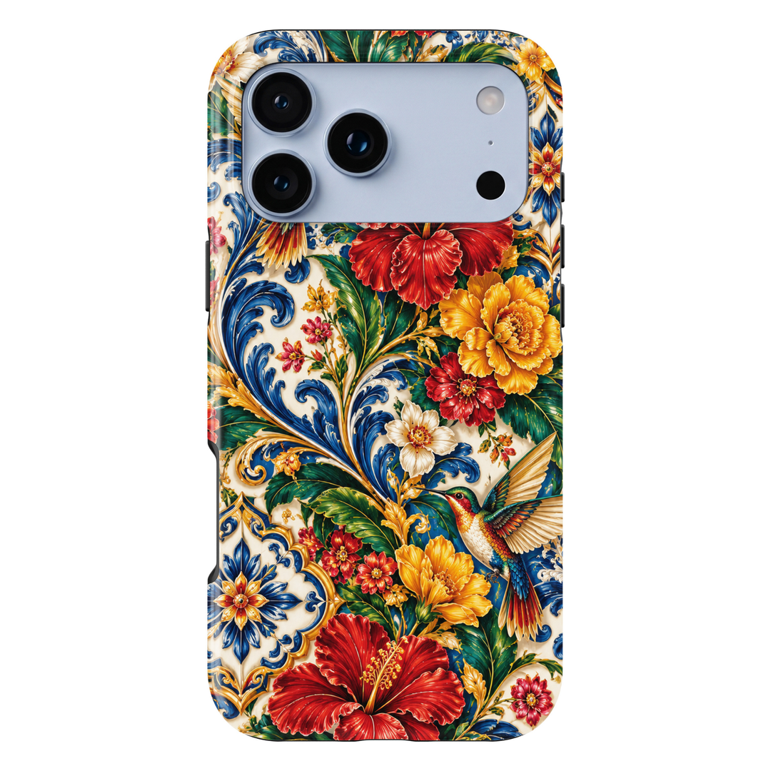 CASELIX Mediterranean Hummingbird Garden iPhone Tough MagSafe protective phone case featuring a vibrant Mediterranean-inspired floral design with an elegant multicolored hummingbird, brilliant red hibiscus blossoms, golden-yellow flowers, lush emerald-green foliage, and intricate cobalt-blue ornamental scrollwork. The luxurious artwork showcases a beautifully detailed hummingbird in flight with shimmering emerald-green, turquoise-blue, ruby-red, and golden feathers, gracefully hovering among richly layered 