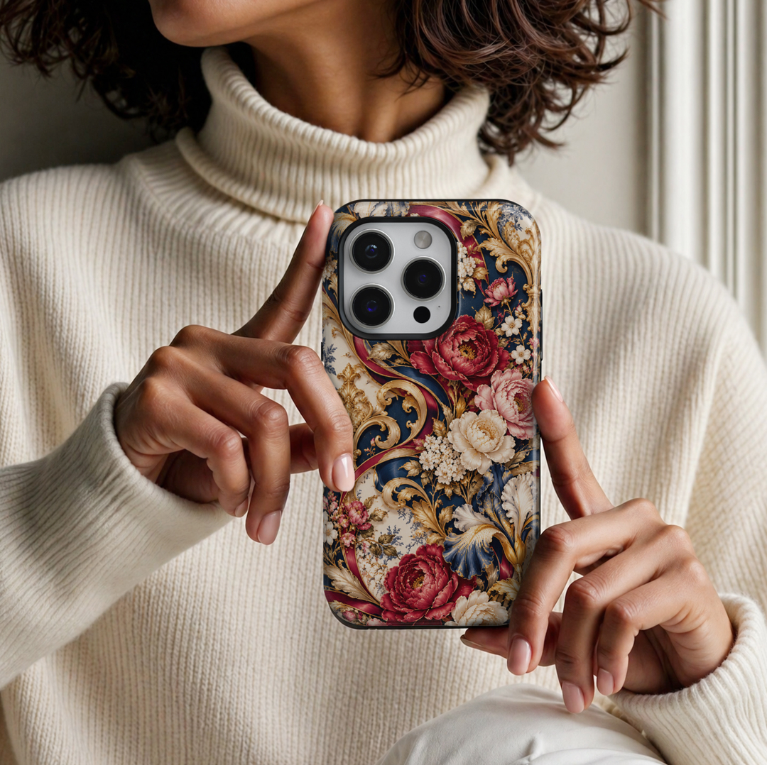 CASELIX Versailles Rose Garden iPhone Tough MagSafe protective phone case featuring an opulent French Baroque-inspired floral pattern with romantic burgundy roses, blush-pink peonies, ivory blossoms, ornate golden scrollwork, and rich midnight-navy accents. The luxurious artwork showcases oversized crimson-red and dusty-rose peonies with intricately layered petals, delicate golden centers, and soft botanical shading, surrounded by elegant cream-white flowers and clusters of miniature blossoms.
