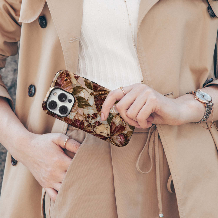 Cabernet Butterfly iPhone 18 Pro Max MagSafe case featuring stained-glass-inspired butterflies and moths in cabernet, burgundy, champagne and bronze with olive foliage and jewel-like berries over a pearlescent background, a luxurious tough iPhone 18 Pro butterfly phone case with MagSafe compatibility.