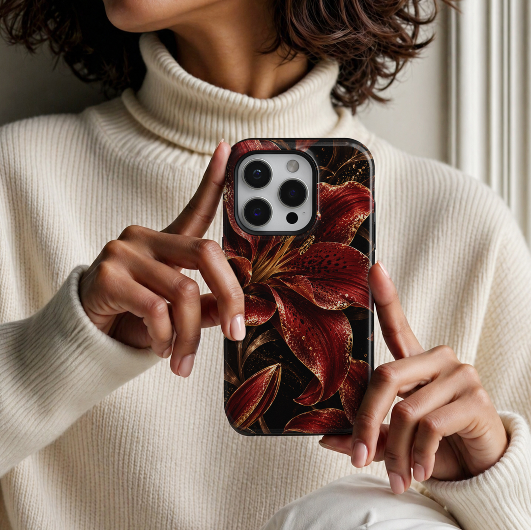 CASELIX Crimson Lily Luxe iPhone Tough MagSafe protective phone case featuring oversized deep crimson-red lilies with dramatic black-speckled petals, shimmering champagne-gold glitter effects, and elegant golden botanical stems against a rich jet-black background. The luxurious floral artwork showcases vibrant ruby-red and burgundy lily blossoms, intricate golden stamens, sparkling metallic-inspired accents, and beautifully detailed flower buds. Stylish red and black lily floral iPhone case with a glossy pr
