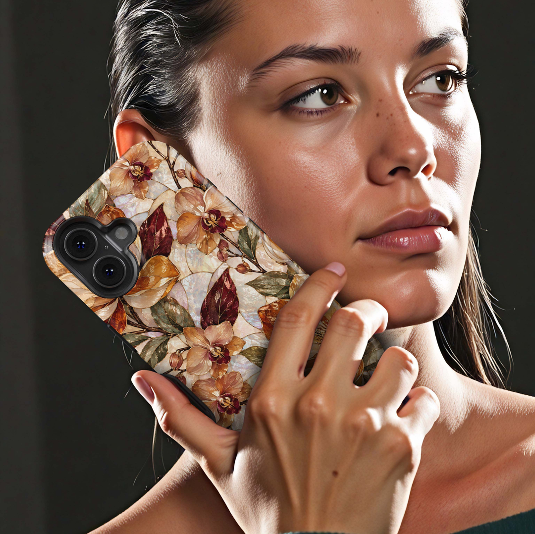 Amber Orchid iPhone 18 Pro Max MagSafe case featuring pearlescent orchids and botanical blooms in amber, champagne, caramel and ivory with burgundy and olive leaves, a luxurious stained-glass-inspired tough iPhone 18 Pro floral phone case with MagSafe compatibility.