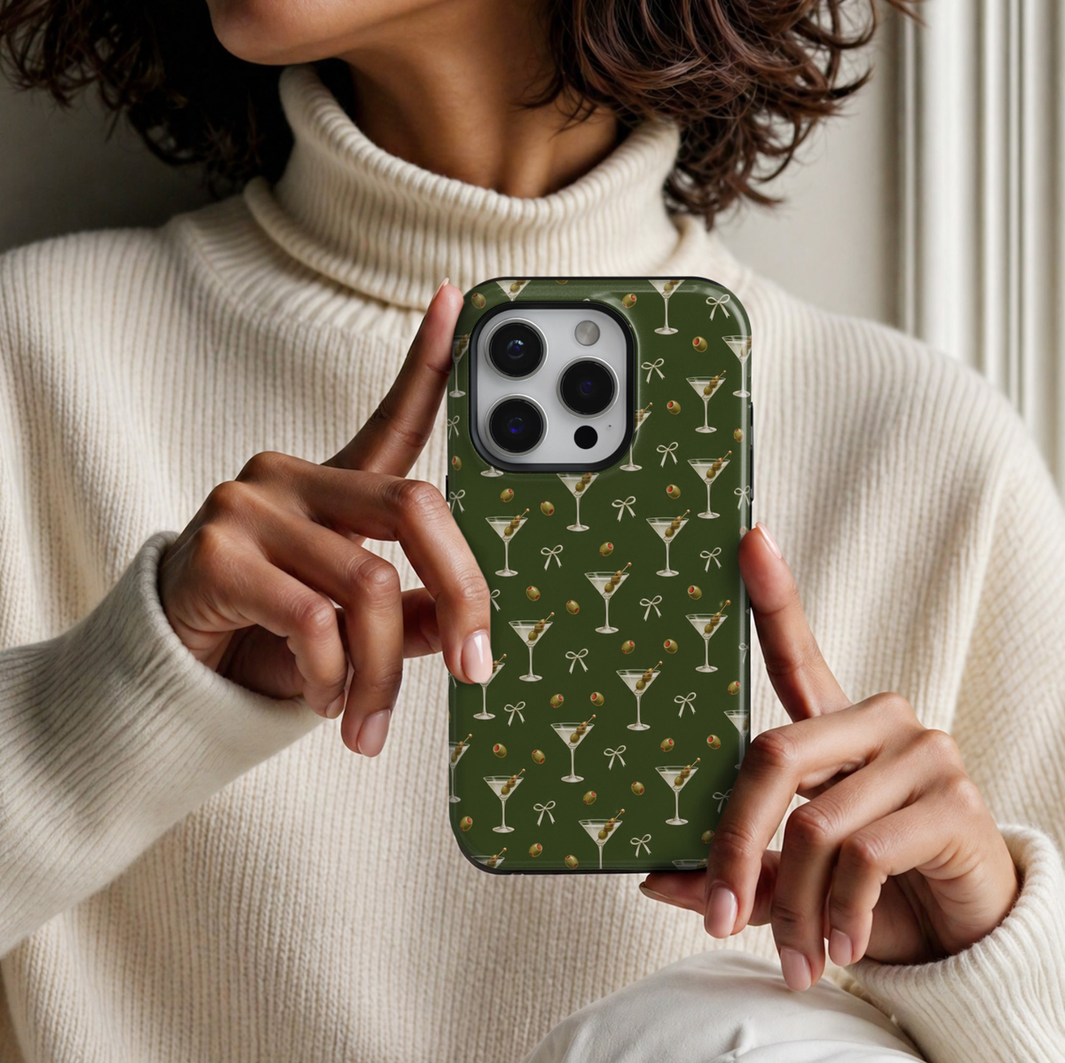 CASELIX Olive Hour iPhone 18 Pro Max tough phone case featuring a deep olive-green background with repeating dirty martini cocktail glasses, green olives with red pimentos, delicate ivory ribbon bows, and miniature olive illustrations. Chic glossy printed phone case for women with a minimalist cocktail-inspired aesthetic and trendy olive-green design.