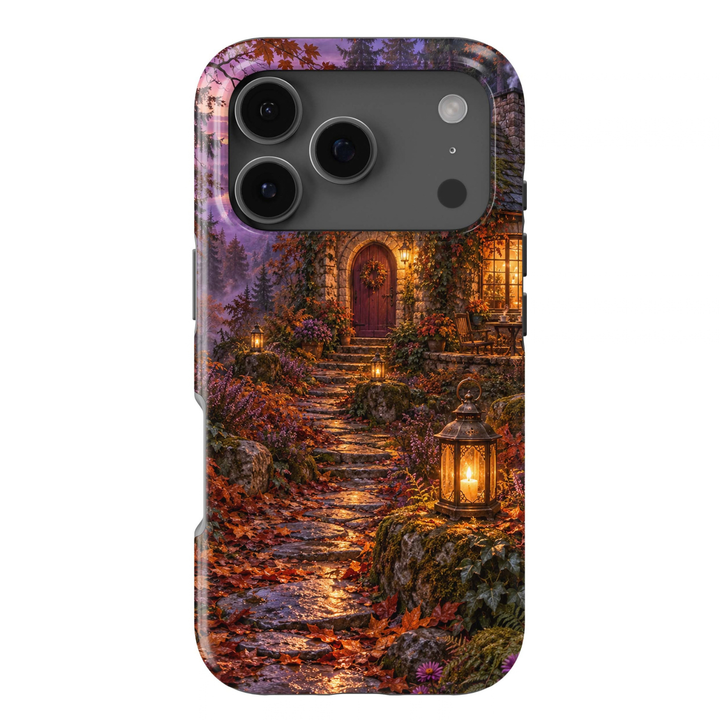Lantern Cottage Tough iPhone Case featuring a cozy stone cottage, glowing lanterns, autumn leaves, woodland flowers and a winding stone pathway at dusk.
