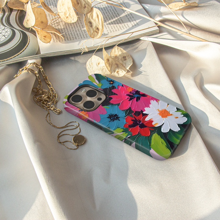 Colorful floral iPhone case featuring bold pink, blue, red, and white flowers with expressive painterly brushstrokes.