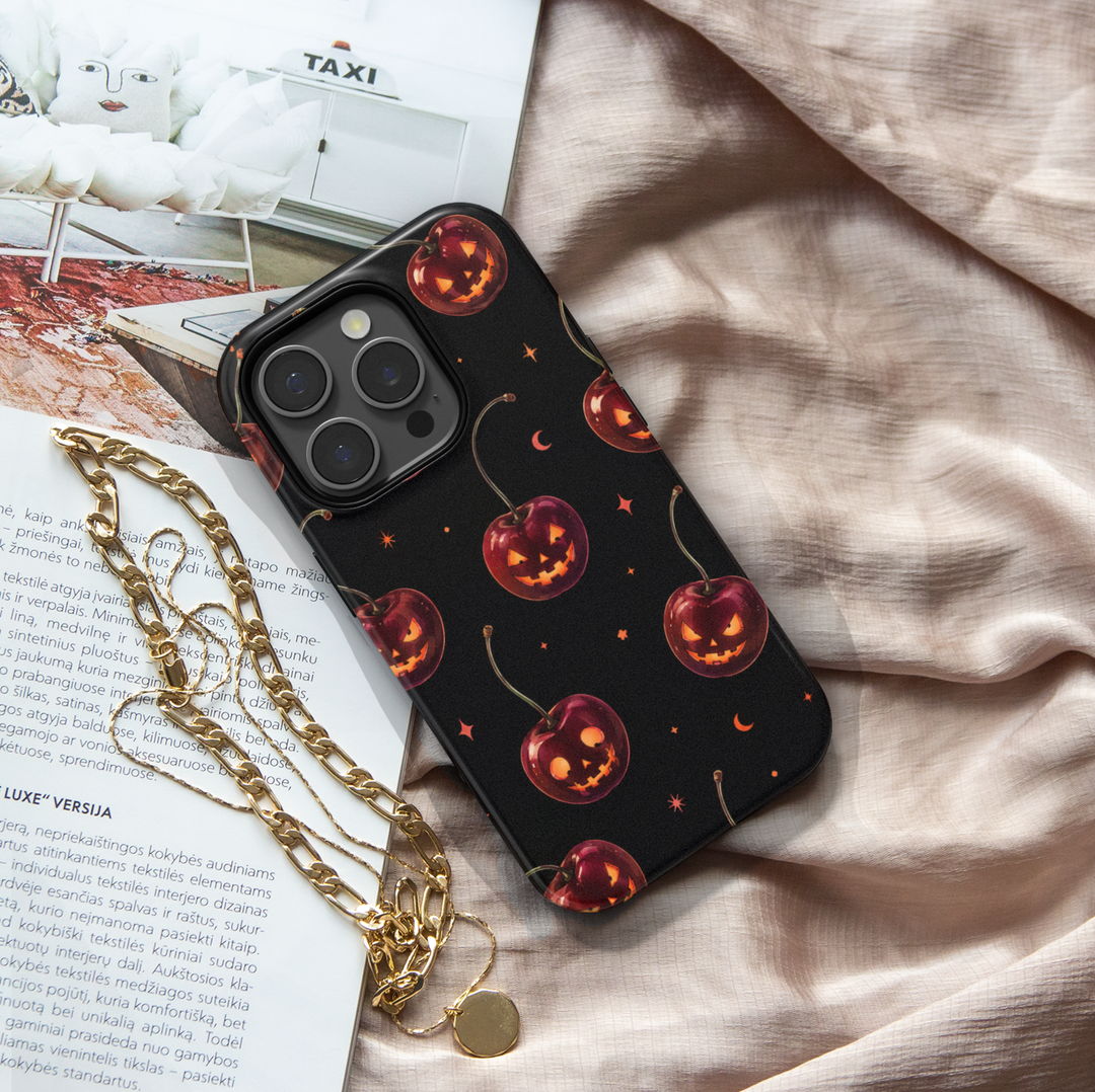 Black Halloween iPhone case with cherry red jack-o-lantern pumpkins, glowing faces, crescent moons and stars.