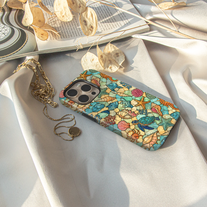 Sea life iPhone case featuring sea turtles, starfish, seashells, tropical fish, coral, and coastal stained glass artwork.