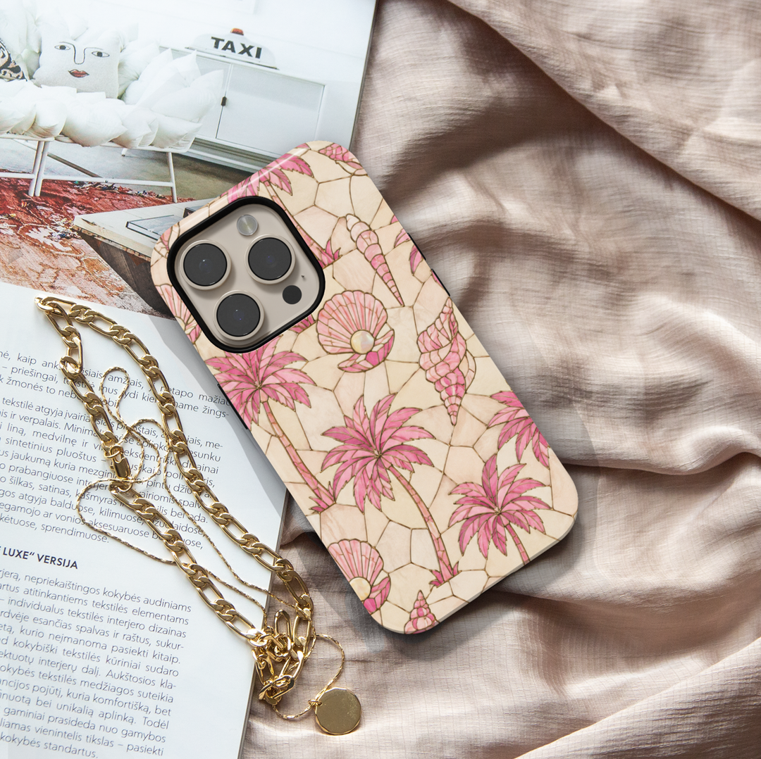 Pink tropical iPhone case featuring palm trees, seashells, pearls, and a soft coastal mosaic design.