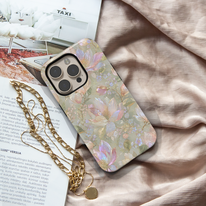 Opal Magnolia iPhone case with pearlescent blush and ivory magnolia flowers, lavender accents and soft sage green background.