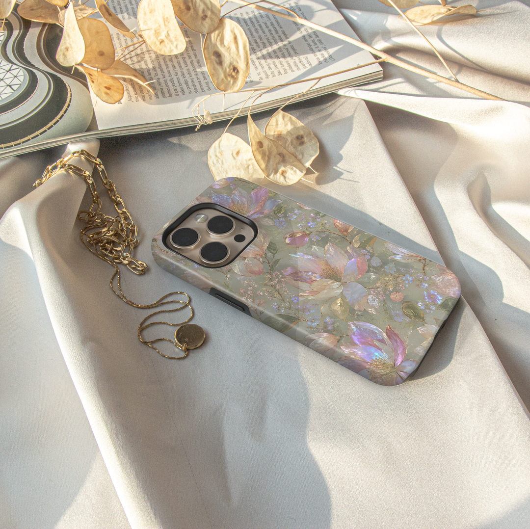 Opal Magnolia iPhone case with pearlescent blush and ivory magnolia flowers, lavender accents and soft sage green background.