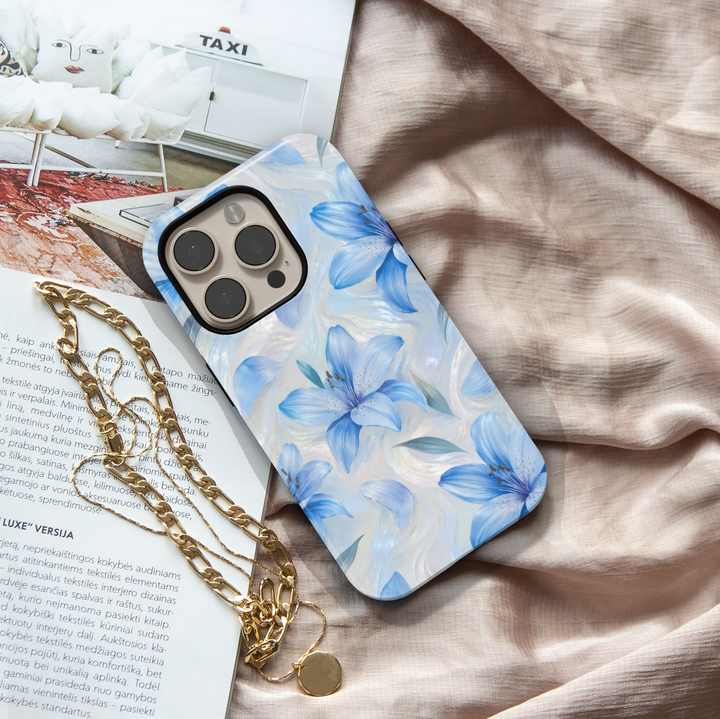 Blue lily floral iPhone case featuring delicate flowers on an iridescent pearl swirl background.