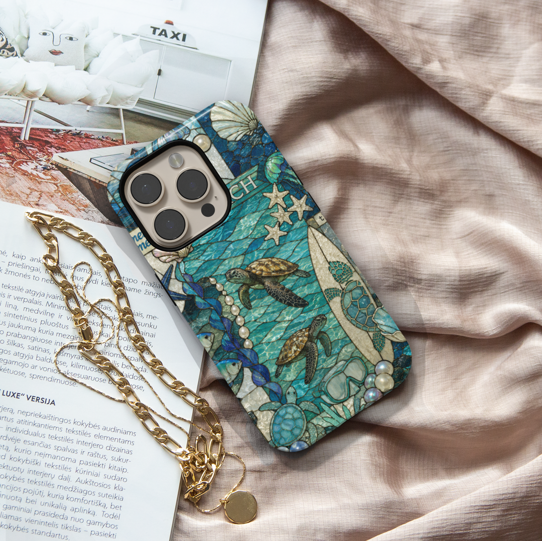 Sea turtle coastal iPhone 17 Pro Max case featuring ocean waves, surfboards, shells, pearls, and tropical beach artwork.