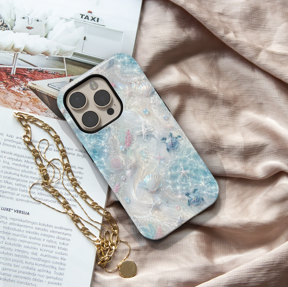 Sea turtle iPhone case featuring seashells, starfish, coral accents, and shimmering ocean waves in soft aqua tones.