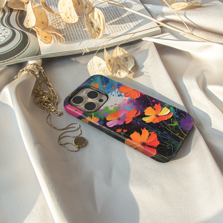 Abstract wildflower iPhone case featuring vibrant orange, pink, yellow, and purple flowers on a colorful artistic background.
