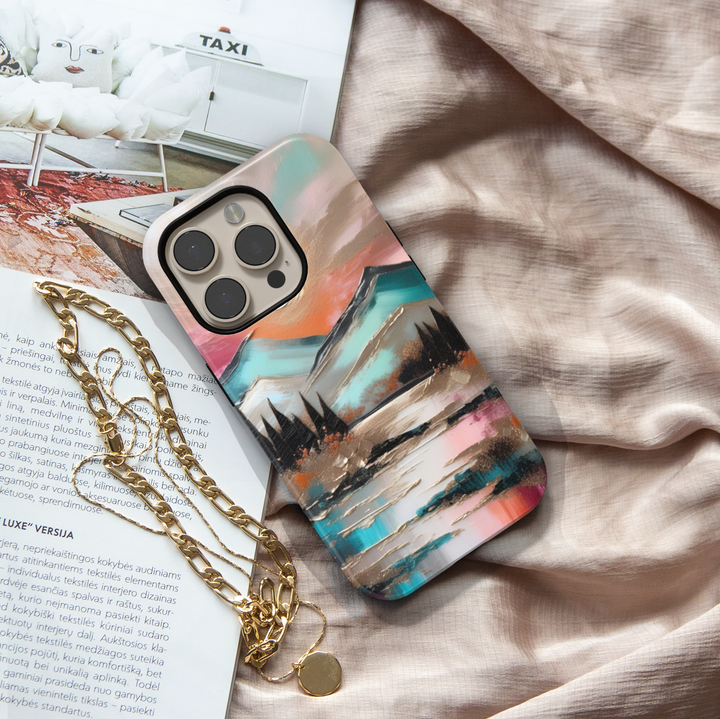 Modern landscape iPhone case featuring turquoise mountains, a reflective lake, and a colorful sunset sky.