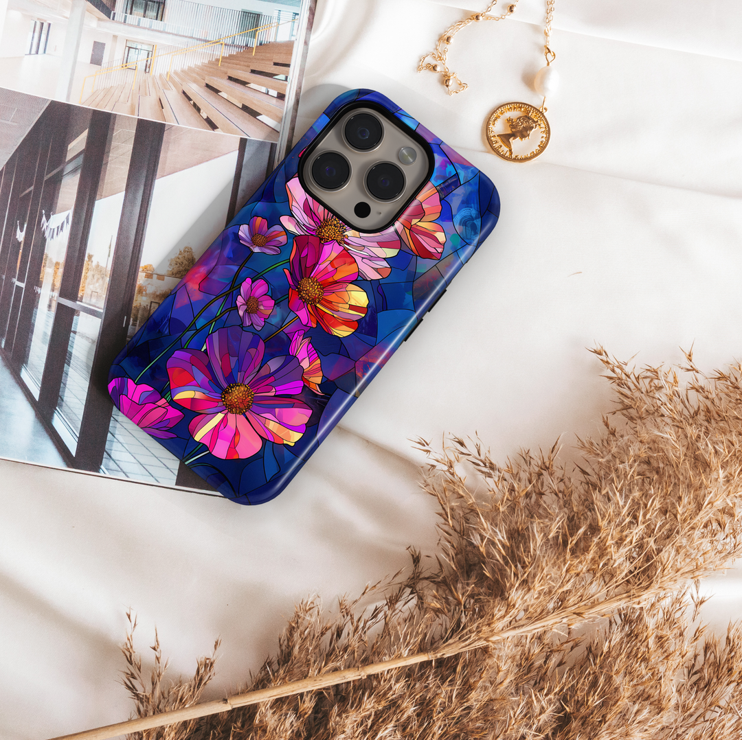 Stained glass style wildflower iPhone tough case with vibrant pink, purple, and orange flowers on deep blue background