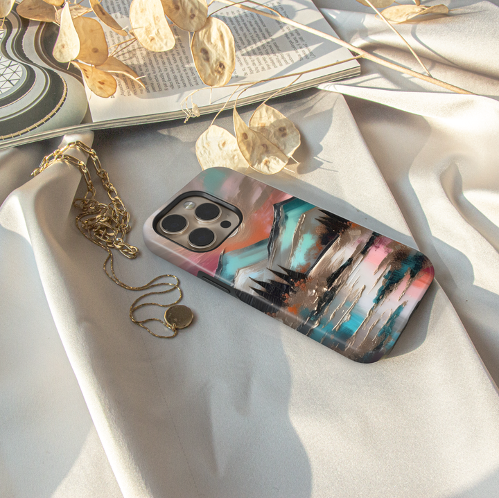 Modern landscape iPhone case featuring turquoise mountains, a reflective lake, and a colorful sunset sky.
