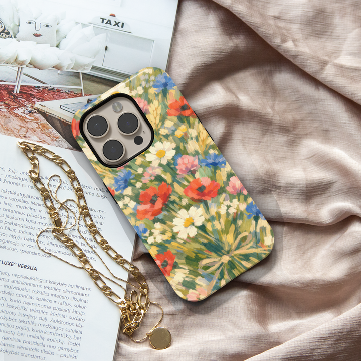 Impressionist wildflower iPhone case featuring colorful poppies, daisies, cornflowers, and meadow flowers in a painterly garden design.