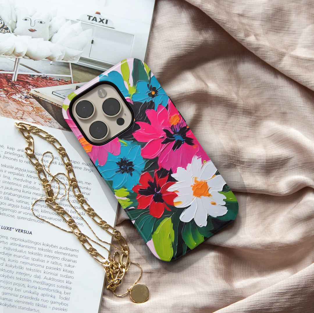 Colorful floral iPhone case featuring bold pink, blue, red, and white flowers with expressive painterly brushstrokes.
