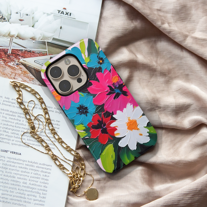 Colorful floral iPhone case featuring bold pink, blue, red, and white flowers with expressive painterly brushstrokes.