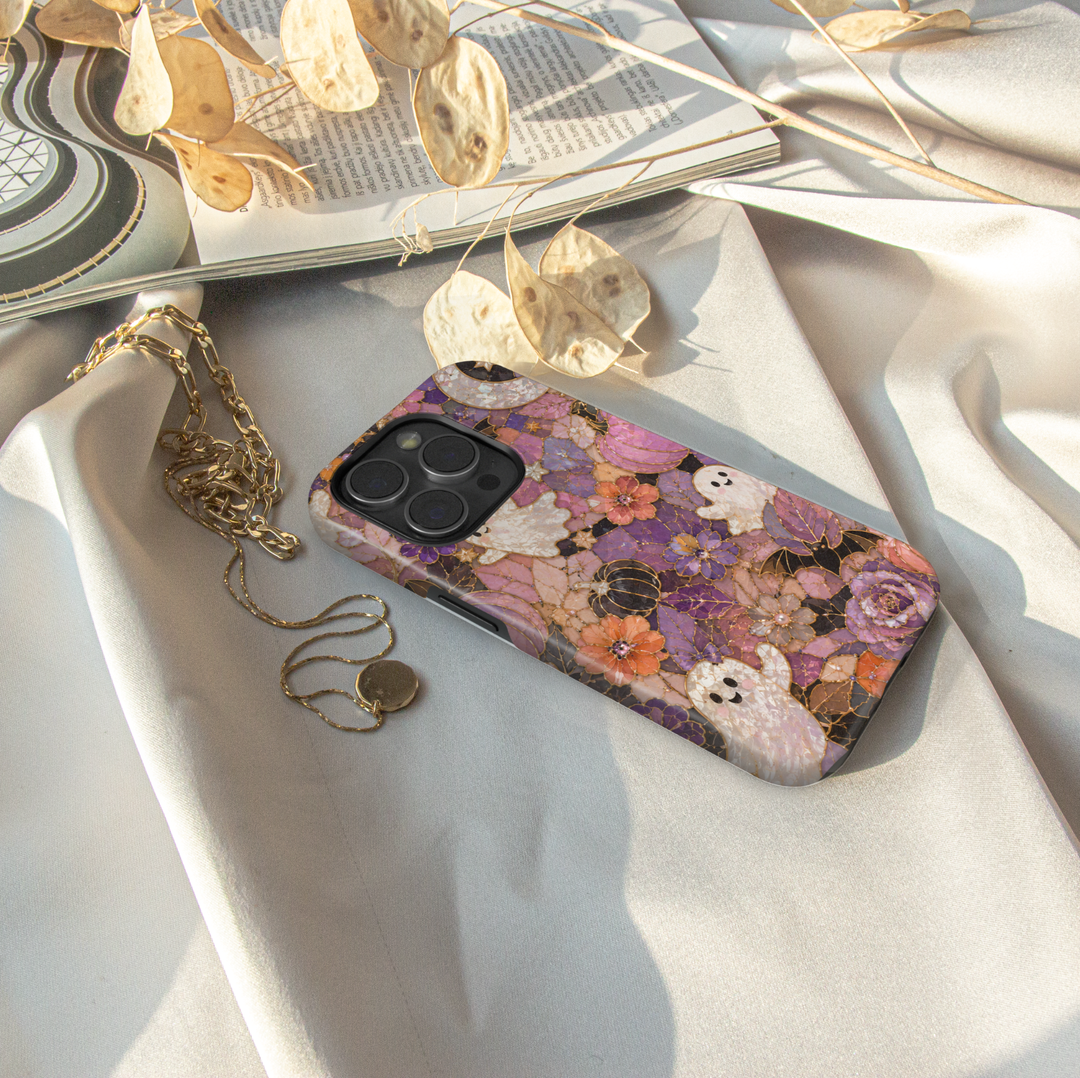 Floral Halloween iPhone case with pearl ghosts, bats, pumpkins, crescent moon and purple pink orange stained glass flowers.