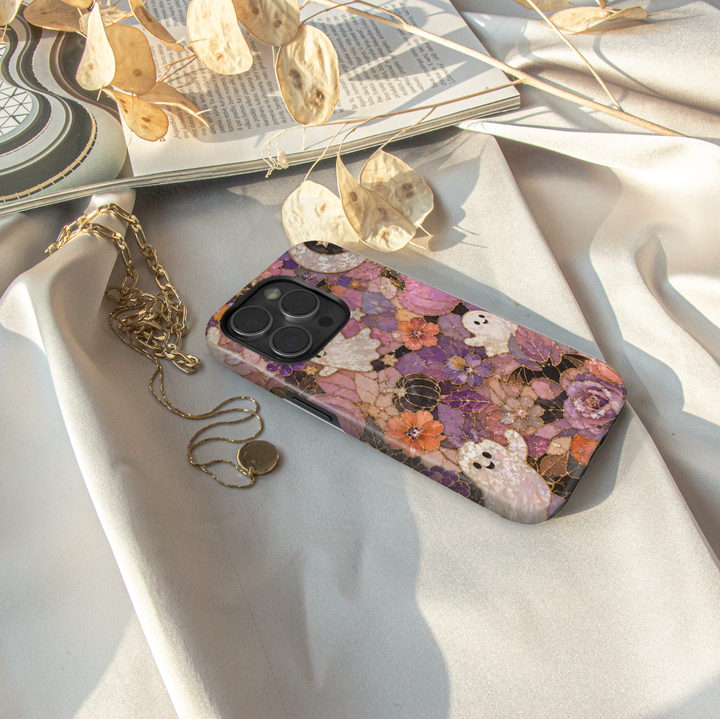 Floral Halloween iPhone case with pearl ghosts, bats, pumpkins, crescent moon and purple pink orange stained glass flowers.