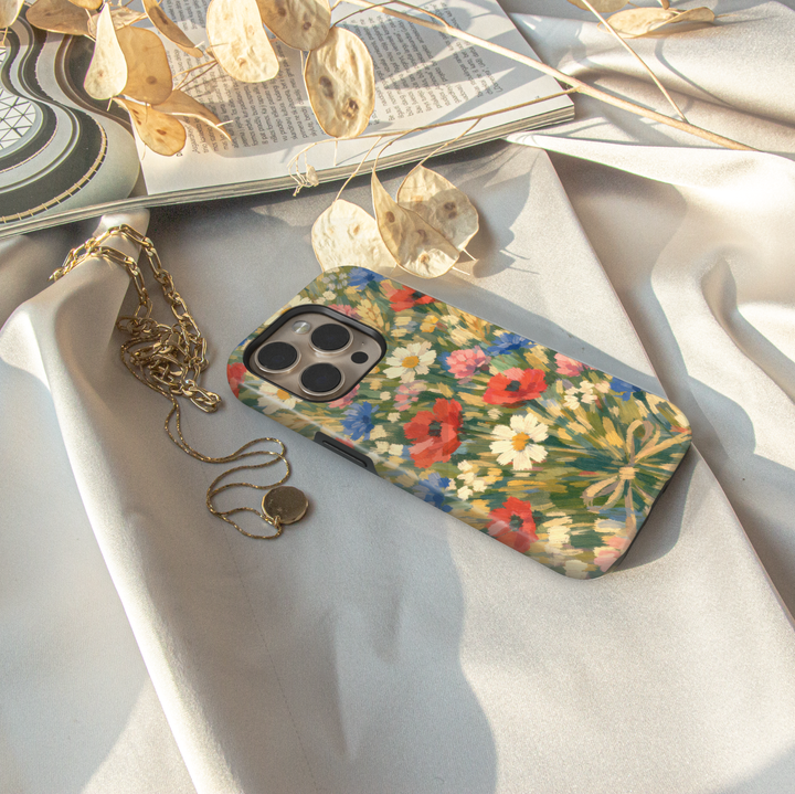 Impressionist wildflower iPhone case featuring colorful poppies, daisies, cornflowers, and meadow flowers in a painterly garden design.