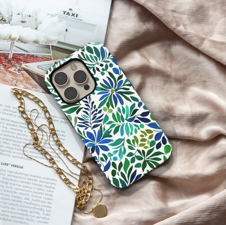 Blue and green botanical iPhone case featuring floral blooms and leafy watercolor-inspired artwork on a white background.